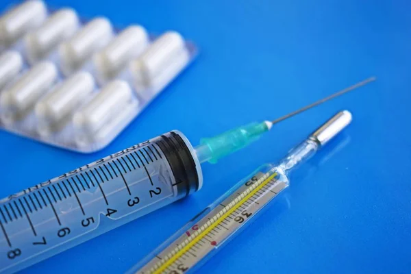 Medizinische Präparation Eine Spritze Und Ein Thermometer Auf Blauem Hintergrund — Stockfoto