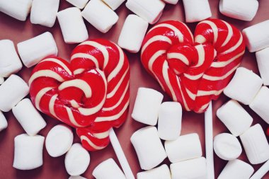 Lezzetli tatlı şekerleme ve pembe bir arka plan üzerinde lolipop.