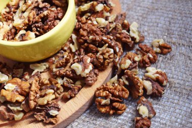 Çuval bezi ve ahşap arka plan üzerinde yararlı ceviz.