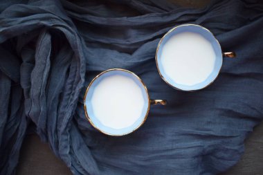 Mavi peçete üzerinde mavi fincan ile süt.