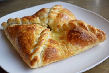 Beyaz bir tabakta sebze ve peynir ile Khachapuri.