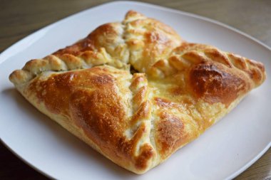 Beyaz bir tabakta sebze ve peynir ile Khachapuri.