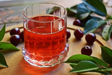 Ahşap arka planda lezzetli ve sağlıklı kiraz içeceği ve taze meyve.