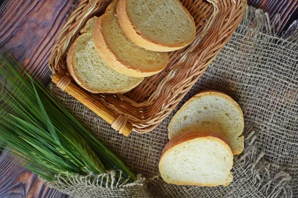 Vers Brood Een Rieten Mand Groene Oren Een Houten Achtergrond — Stockfoto