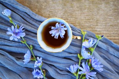 Sağlıklı bir bitki içeceği. Kahvenin yerine hindiba geçer. Yukarıdan manzara. Diyet içecek ve mavi çiçekler.