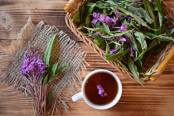 Traditional Russian herbal drink. Ivan-tea in a Cup close-up on a wooden table. It has a positive effect on the human body.