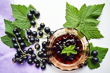 Olgun, tatlı siyah frenk üzümü ve beyaz arka plan üzerinde lezzetli reçel.