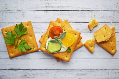 Peynir sosu ve sebze ile lezzetli kraker. Ahşap arka planda atıştırmalık.