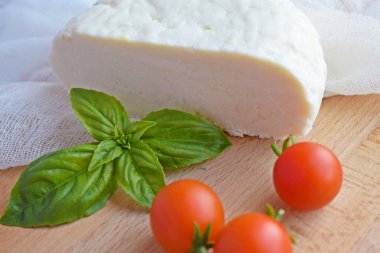 Ahşap tahta üzerinde yatan ev yapımı dilimlenmiş Adyghe peyniri.