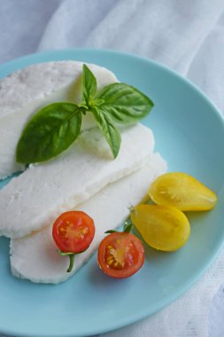 Ahşap tahta üzerinde yatan ev yapımı dilimlenmiş Adyghe peyniri.