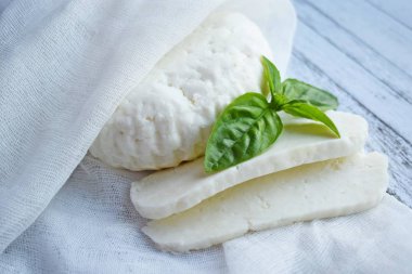 Ahşap tahta üzerinde yatan ev yapımı dilimlenmiş Adyghe peyniri.