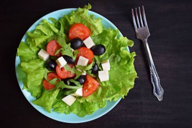 Yeşil domatesli hafif salata ve mavi tabakta peynir. Vejetaryen yemeği..