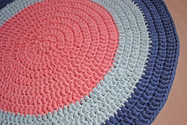 Round rug made of handmade knitted yarn.Crocheting.It will add warmth and comfort to the interior of the house.