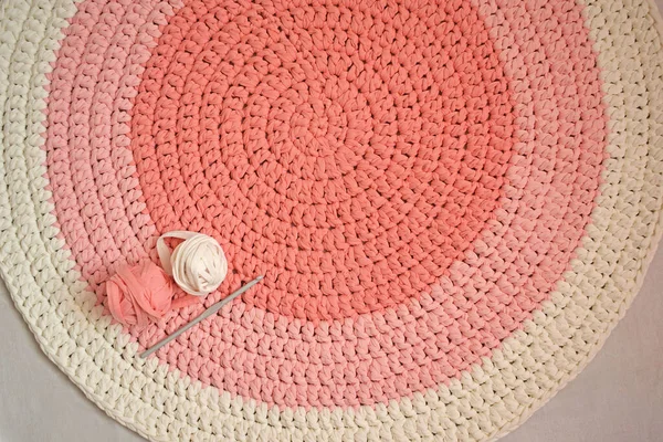 Round pink handmade rug.Crocheting from knitted yarn.