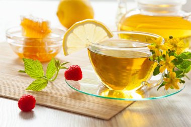 Tatlım, taze ahududu ve Bambu zemin üzerine limon ile bitkisel çay güzel kompozisyon servis