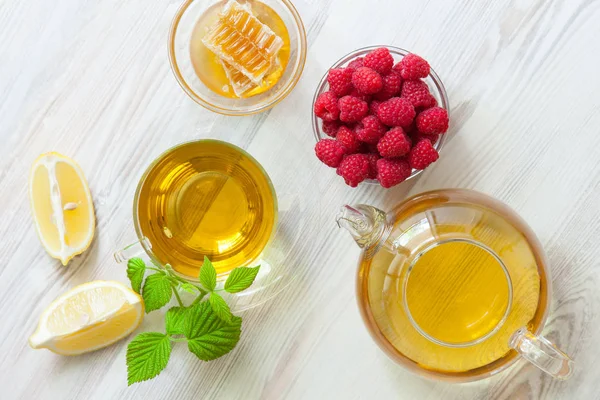 Hızlı kurtarma için doğal ilaçlar bileşimi: bal, taze ahududu, bitkisel çay ve limon; üst bakış açısı