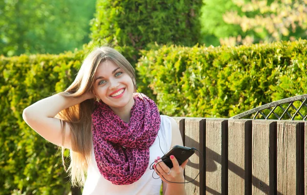 Mooi Lachende Student Meisje Muziek Beluisteren Haar Mobiele Telefoon Zit — Stockfoto
