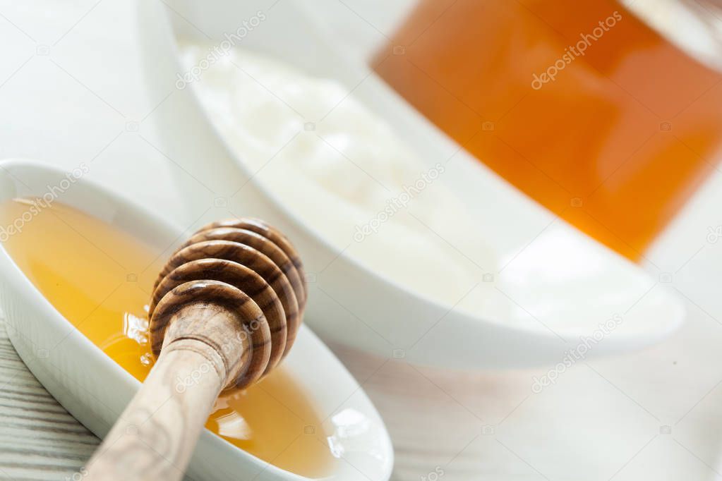 Fresh honey and milk yogurt in porcelain tableware on a wooden table