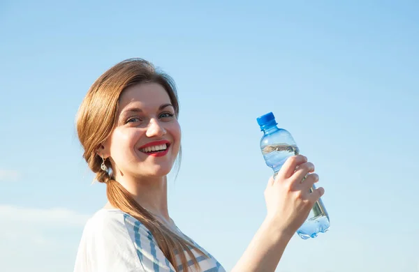 纯净水健康和积极的生活方式 愉快的年轻妇女拿着瓶饮用水对蓝天 — 图库照片