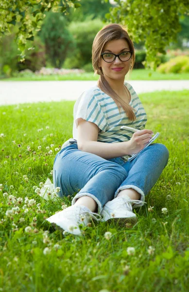 Hezká Mladá Studentka Dělala Poznámky Deníku Sedí Slunném Trávníku Parku — Stock fotografie