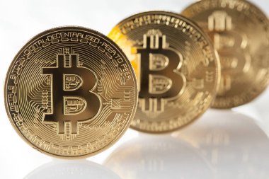 Yansıması ile beyaz arka plan üzerinde parlak altın bitcoins