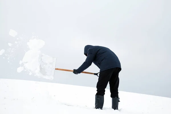 大雪后从屋顶上除雪的人 — 图库照片