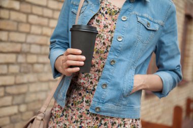 Bir fincan kahve açık havada tanınmaz halde genç kadın