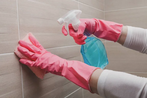 Femme de ménage dans les gants en caoutchouc nettoyage salle de bains avec une éponge — Photo