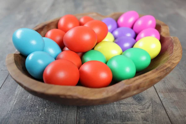 Huevos de Pascua multicolores en un hermoso tazón de madera — Foto de Stock