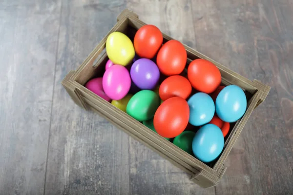 Многоцветные пасхальные яйца в деревянной коробке — стоковое фото