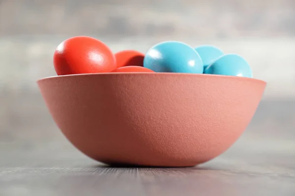 Ovos de Páscoa multicoloridos em uma tigela de barro — Fotografia de Stock
