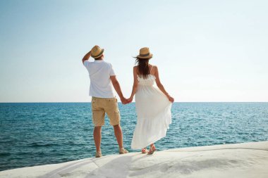 Beyaz taşlı sahilden deniz izlerken romantik genç çift, Kıbrıs.