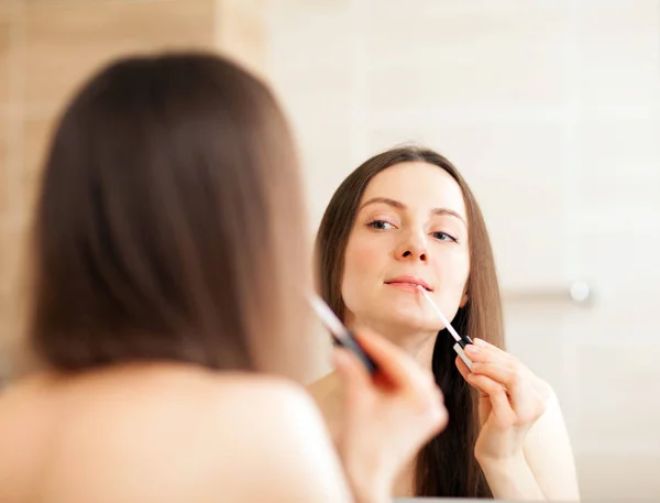 Mujer Joven Aplicando Brillo Labios Delante Del Espejo — Foto de Stock