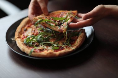 Kafede masada koyu plaka lezzetli pizza