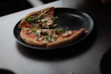 Kafede masada koyu plaka lezzetli pizza