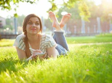 Genç kadın harcama boş zaman içinde güneşli Park yapma notlar içinde Diary