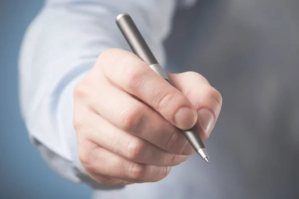 Hand of businessman giving pen to sign contract