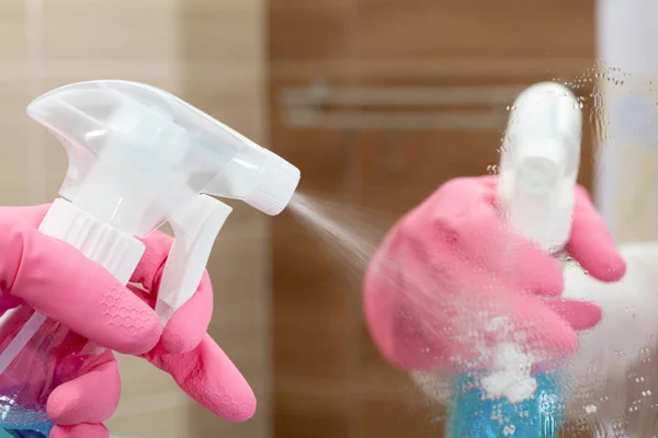 Empregada doméstica nas luvas de borracha limpando o banheiro com uma esponja — Fotografia de Stock