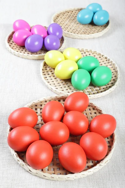 Veelkleurig paaseieren op rieten stro stands — Stockfoto