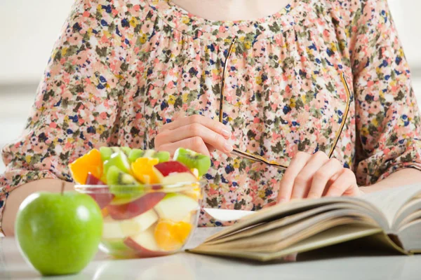 Unrecognizable young woman reading a book at lunch time — Stock Photo, Image