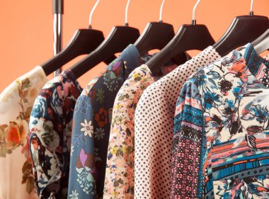 Trendy kadınsı giysiler kırmızı arka planda üst üste asmak