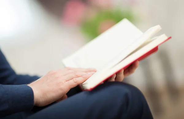 Onherkenbaar Jonge Man Lezen Boek Zittend Ontspannen Pose Woonkamer Close — Stockfoto