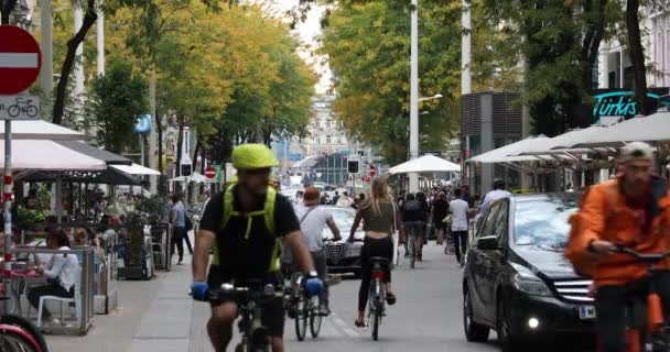 Wiedeń, Austria - 16 września: Typowe wiedeńskie życie miejskie, ludzie spacerują i jeżdżą na rowerze po deptaku Mariahilfer Strasse, który jest bardzo zajęty ulicą handlową — Wideo stockowe