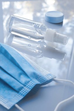 Beyaz arka planda maske ve el dezenfektanı