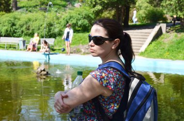 Kadın turist bir sırt çantası ve bir şişe su ile