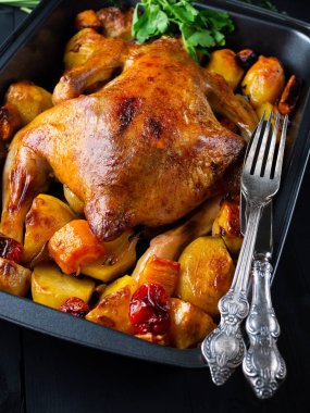 Fried chicken sebze siyah ahşap zemin ile. Sonraki eski çatal ve bıçak. Dikey.