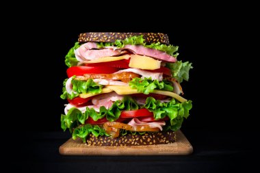 Siyah bir arka plan üzerinde büyük iştah açıcı sandviç.