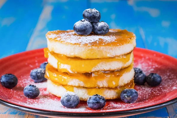 Reçel ve mavi zemin üzerine taze yaban mersini ile pişirme tatlı.