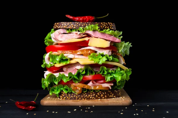 Siyah bir arka plan üzerinde büyük iştah açıcı sandviç.