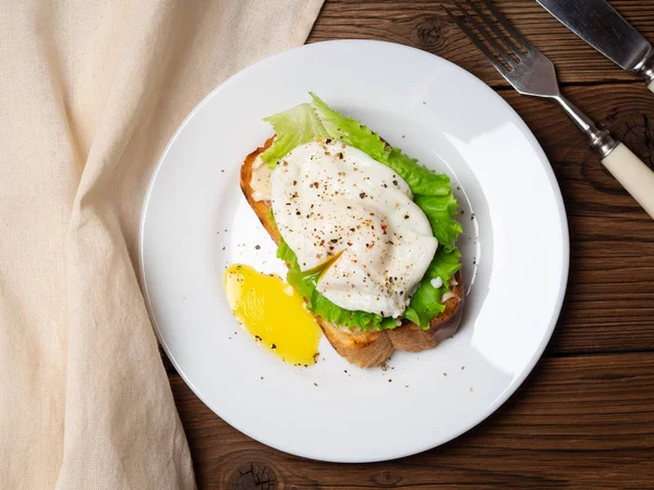 Lezzetli doyurucu kahvaltı - kızarmış ekmek, peynir, yumurta ve ahşap masa salataya haşlanmış. Görünümün üst